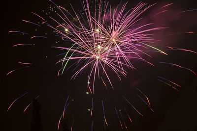 Low angle view of firework display at night