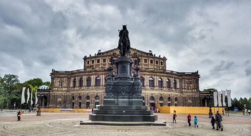 Facade of historical building against cloudy sky