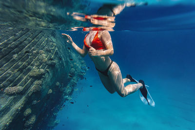 Woman swimming underwater in sea