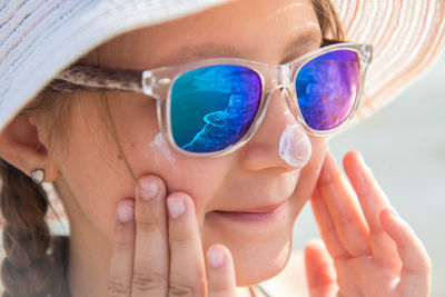 Close-up portrait of woman drinking sunglasses