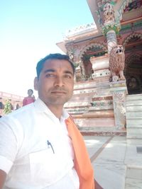 Portrait of young man standing against temple