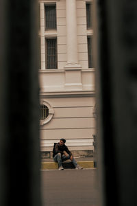 Rear view of woman standing in front of building