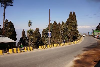 Road amidst trees against sky