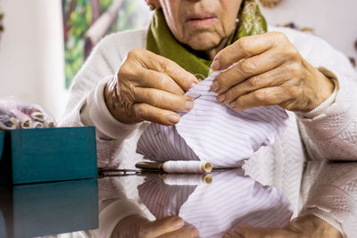 Senior woman sewing mask at home