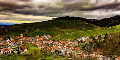 Scenic view of town against cloudy sky