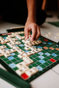 Cropped hand of person holding jigsaw puzzle on table