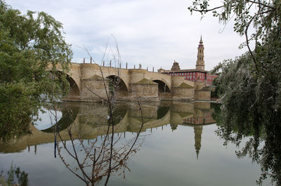 Arch bridge over river against buildings