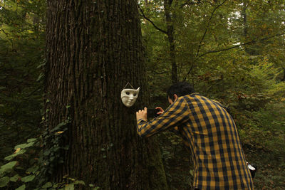 Rear view of man standing in forest