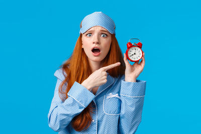 Portrait of a young woman against blue background