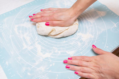 Dough preparation, cooking at home. female hands roll out the dough on a silicone mat