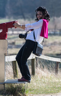 Portrait of smiling woman hanging from binocular