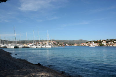 Boats in harbor with cityscape in background