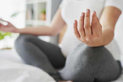 Low section of woman sitting on floor at home