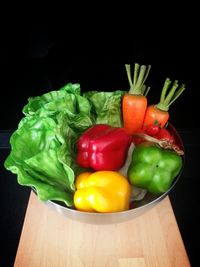 Close-up of bell peppers on table against black background