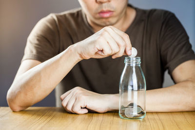 Midsection of man sitting on table