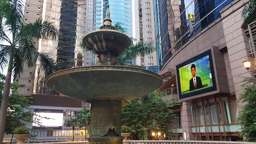 Low angle view of statue amidst buildings in city