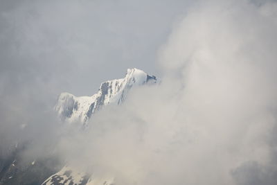Low angle view of snowcapped mountain against sky