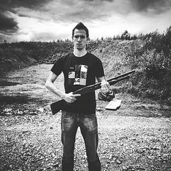 Portrait of young man standing against sky