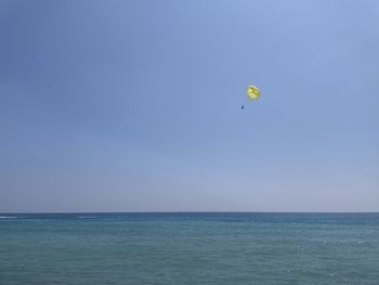 Parasailing scenic view of sea against clear sky 