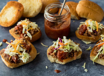 Toasted pulled pork sliders topped with homemade barbecue sauce.