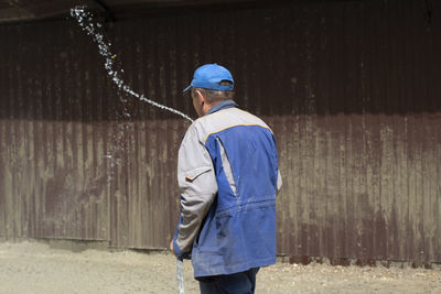Rear view of man standing against wall