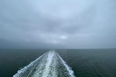 Scenic view of sea against sky with trace of a ferryboat