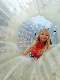 Portrait of smiling cute girl in zorb ball