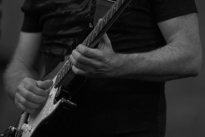 Midsection of man playing guitar