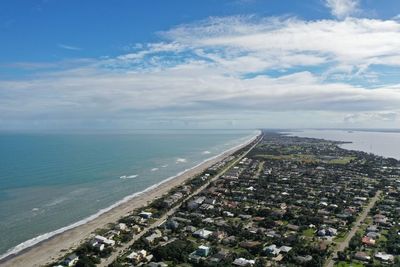 Aerial view of sea and buildings against sky