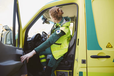 Female paramedic closing door of ambulance