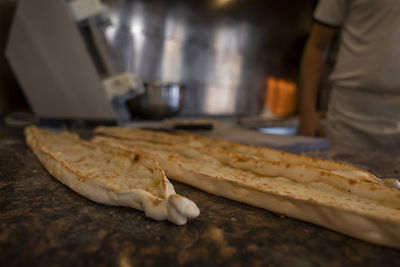 Turkish pide with cheese on counter at restaurant