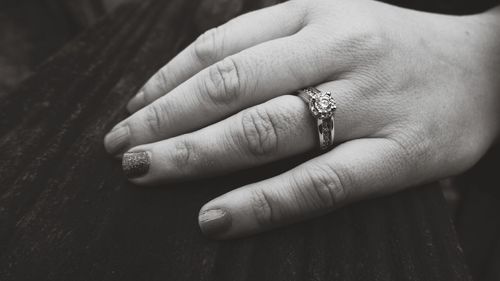 Close-up of woman showing off ring on table