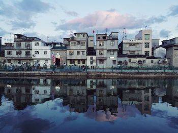 Reflection of buildings on river at sunset