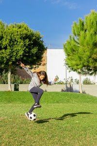 Full length of girl playing soccer at park