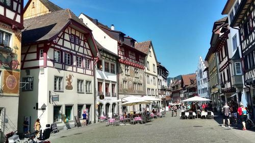 People on street amidst buildings in city