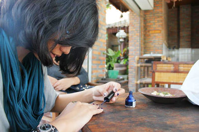 Young lady polish her nail