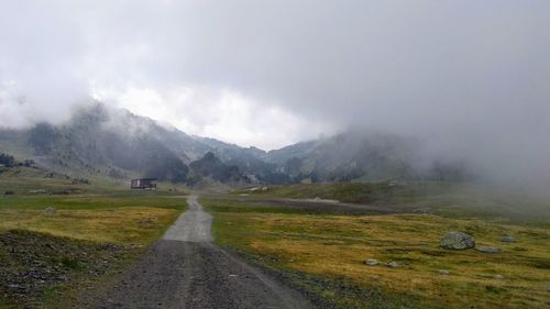 Road by mountains against sky