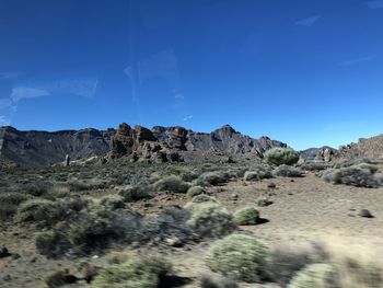 Scenic view of rocky mountains against blue sky