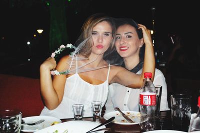 Portrait of female friends smiling while sitting at restaurant