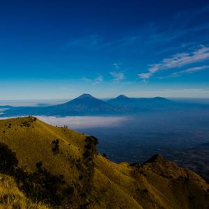 Scenic view of landscape and mountains against blue sky