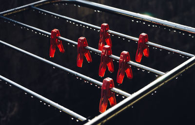 Clothespins hanging on wet metallic rod