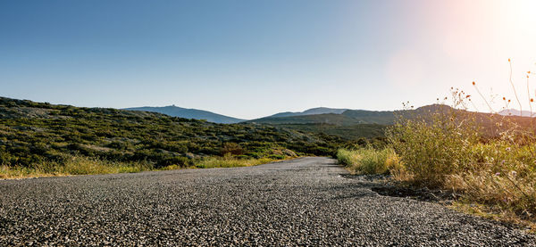 Road by mountains against clear sky