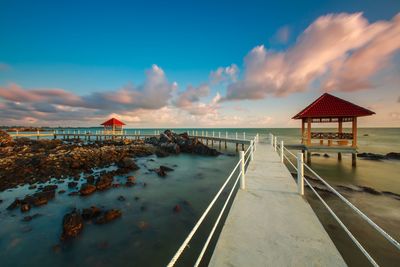 Lifeguard hut on beach against sky during sunset