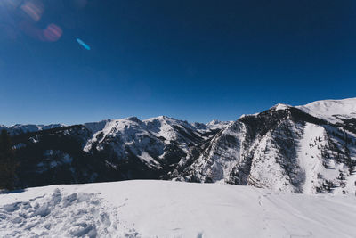 Snowcapped mountains against clear blue sky