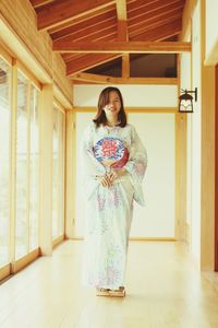 Woman in traditional clothing standing at home