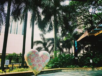 Close-up of heart shape by swimming pool against trees