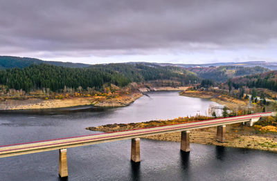 Aerial view over a bridge over a dam in a german mountain range