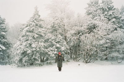 Woman standing on snow covered land