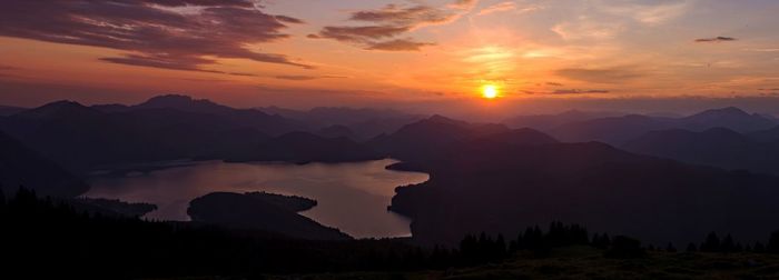 Scenic view of silhouette mountains against orange sky