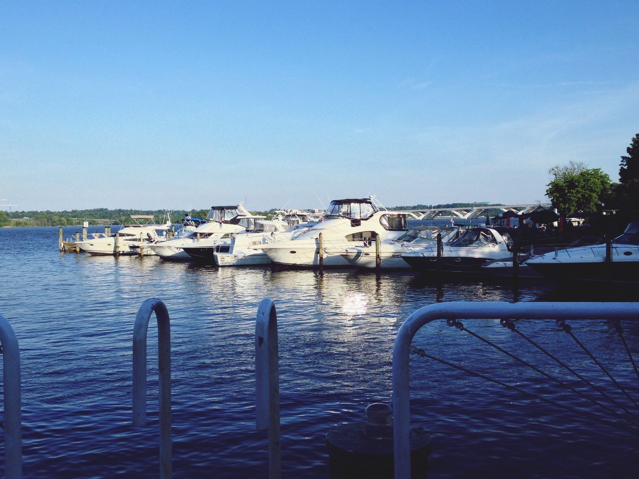 water, clear sky, built structure, architecture, blue, building exterior, copy space, nautical vessel, railing, river, sea, transportation, boat, rippled, day, mode of transport, sunlight, waterfront, harbor, outdoors